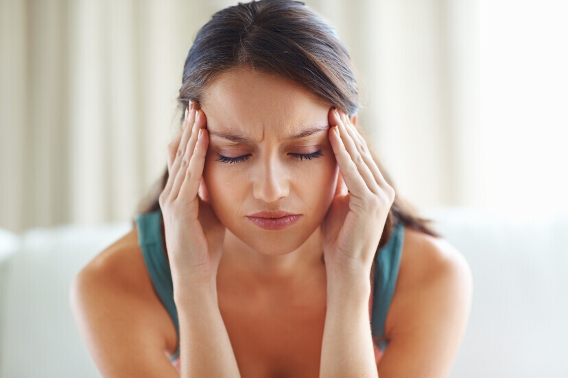 Woman holding her head with headache symptoms after a concussion injury